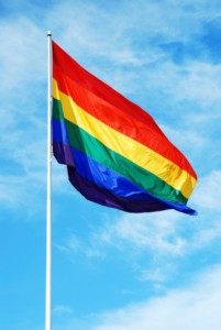 Rainbow gay pride flag on the blue sky