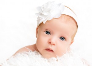 cute  newborn baby girl with a pink flower ribbon
