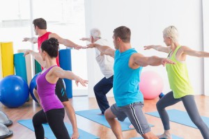36413109 - fit men and women doing warrior pose in yoga class
