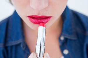 38311481 - woman putting red lipstick on white background