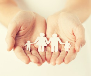 40249652 - close up of womans cupped hands showing paper man family