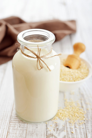 32445150 - quinoa milk in glass bottle on wooden background
